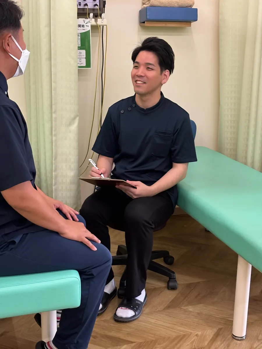 患者様のお話を伺う男性スタッフ