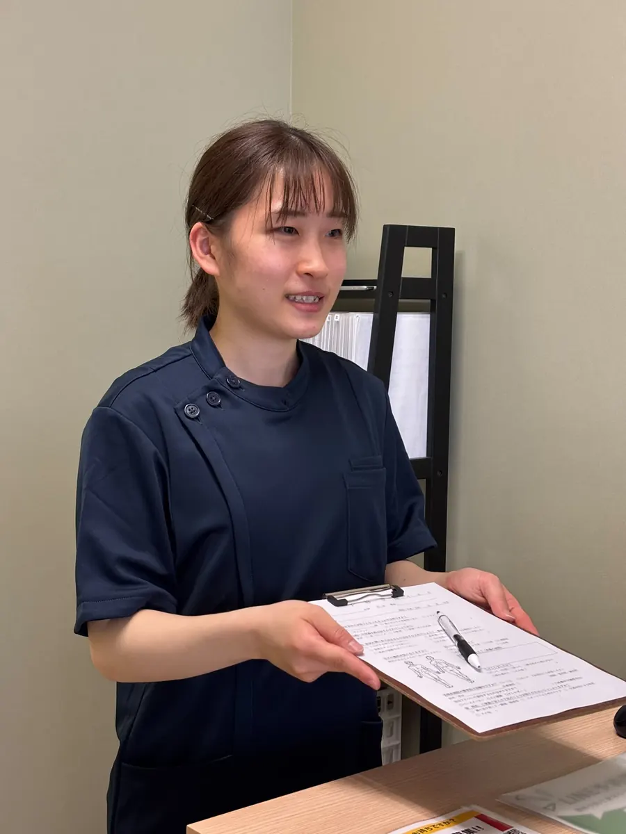 書類を使ってご案内する女性スタッフ