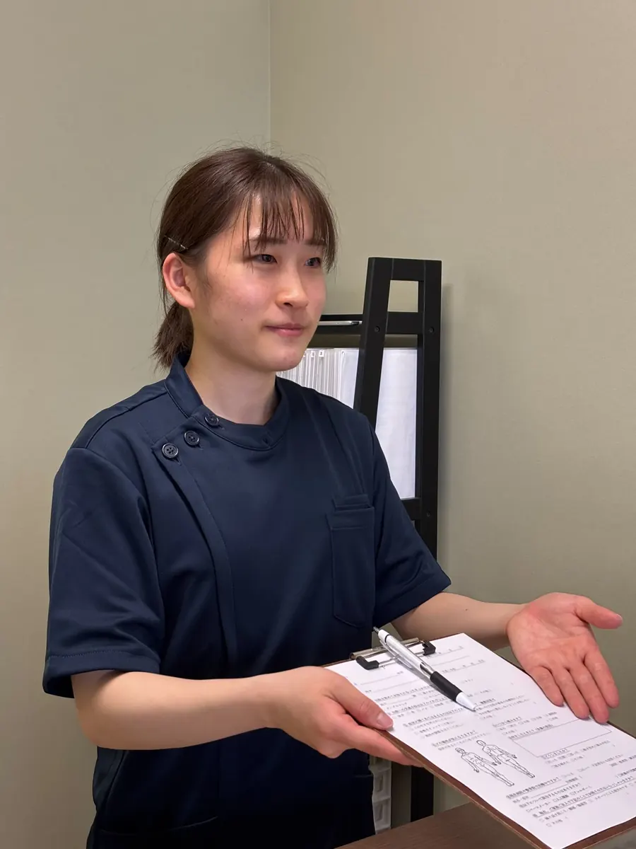 資料を確認しながら説明する女性スタッフ