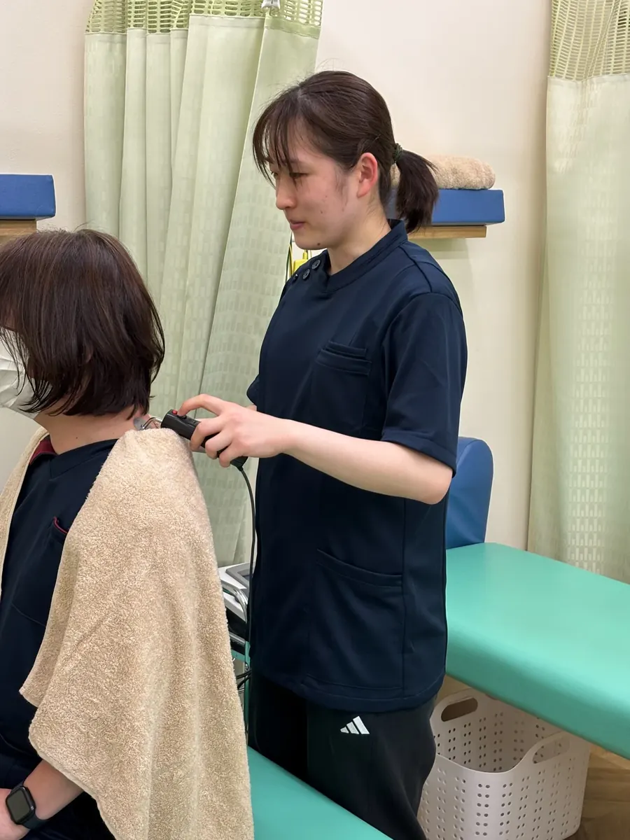 首や肩の状態を確認する女性スタッフ