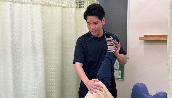 脚のストレッチをしながら体の使い方を確認する様子