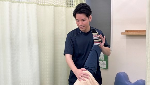 脚のストレッチをしながら体の使い方を確認する様子