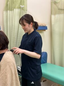 肩へのハイボルテージによる施術の様子