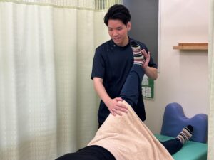 脚や股関節の動きを確認しながらの施術の様子