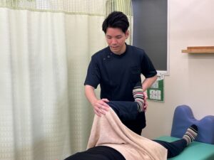 脚や股関節の動きを確認しながらの施術の様子